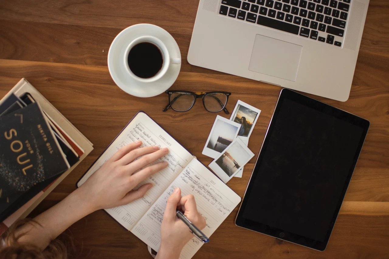 Une femme prend des notes sur son cahier avant de rédiger son article