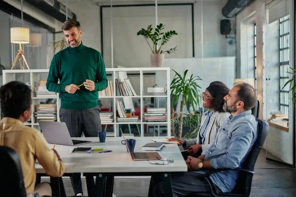 Sur la photo, nous voyons un groupe de travail de 4 personnes. Il est facile d'imaginer qu'ils sont dans une agence digitale et qu'ils échangent sur un projet Web