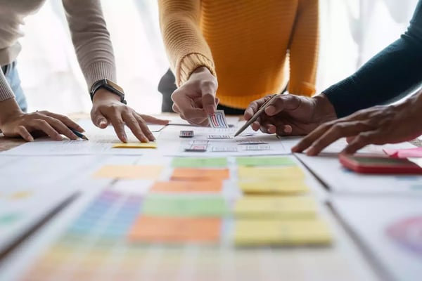 Sur cette photo, nous voyons 3 personnes échangeant sur un projet d'UX Writing