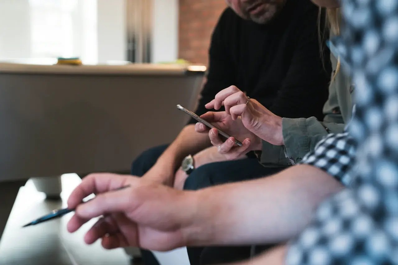 Une femme passe un test utilisateur sur un téléphone portable et un observateur regarde son fonctionnement