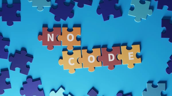 Sur la photo, nous voyons des pièces de puzzle avec le mot No-Code écrit.