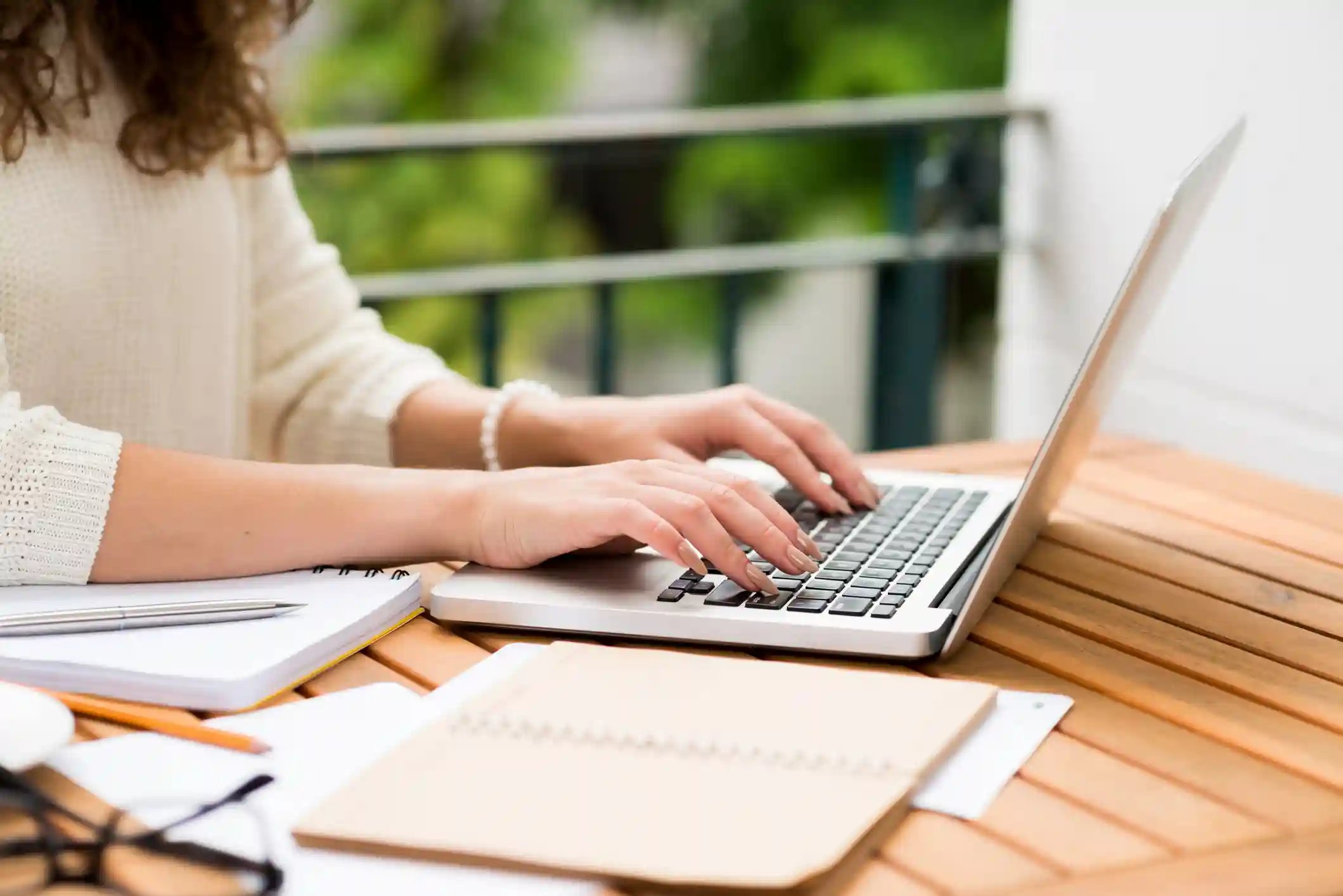 Une femme rédige un document sur son ordinateur portable