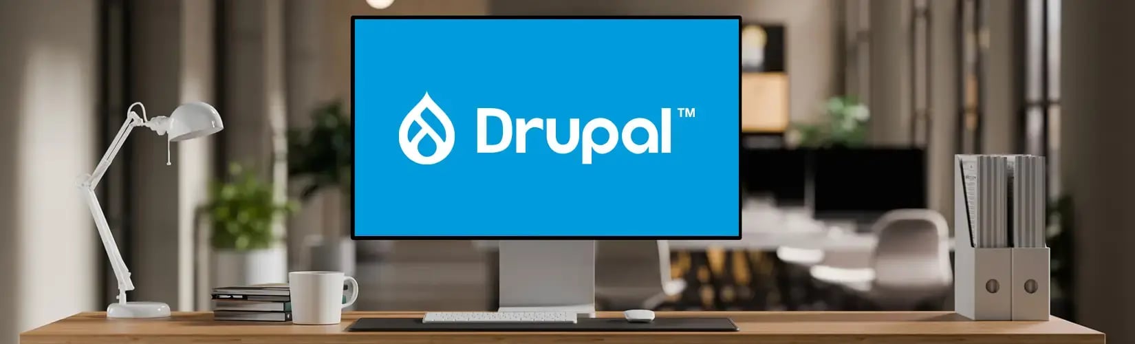 Un open space avec un écran d'ordinateur affichant le logo de Drupal sur un fond bleu
