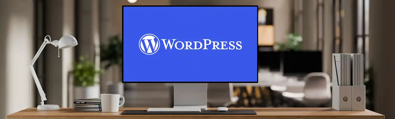 Un open space avec un écran d'ordinateur comprenant le logo WordPress en blanc sur un fond bleu