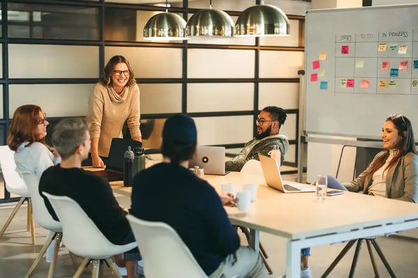 Une cheffe de projet engage son équipe métier dans une gestion de projet digital efficace lors d’une réunion