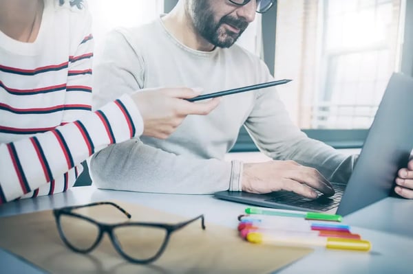 Sur la photo, deux personnes rédigent un article de blog