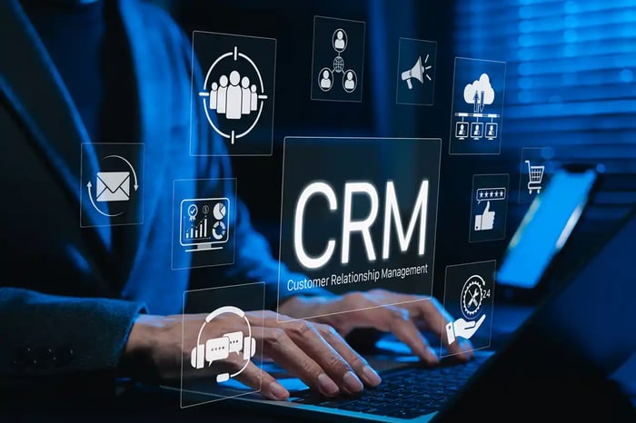 Système CRM, comme HubSpot. Utilisation d’un ordinateur portable avec des icônes CRM numériques représentant la gestion de la relation client, l’automatisation du marketing, l’analyse, les outils d’engagement, etc.
