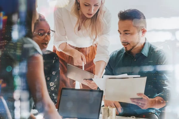 Une équipe en réunion travaillant avec une tablette numérique sur un projet d'intranet