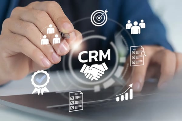 Interface CRM affichée sur un ordinateur avec icônes de gestion client, données et suivi commercial