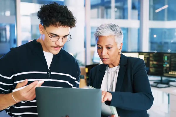 Deux professionnels analysent des données sur un ordinateur portable avant la refonte d’un site Web