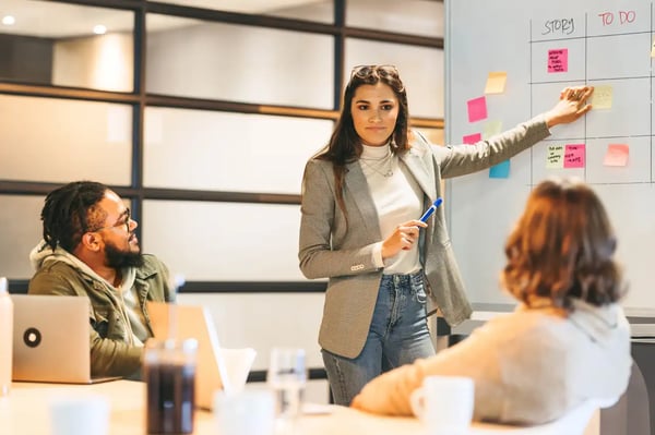 Une cheffe de projet engage son équipe métier dans une gestion de projet digital efficace lors d’une réunion