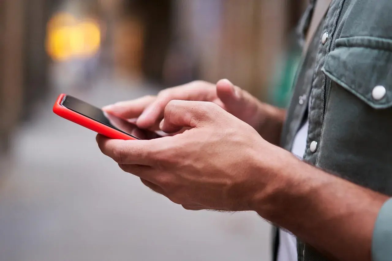 Un homme fait une recherche sur son téléphone portable en pleine rue